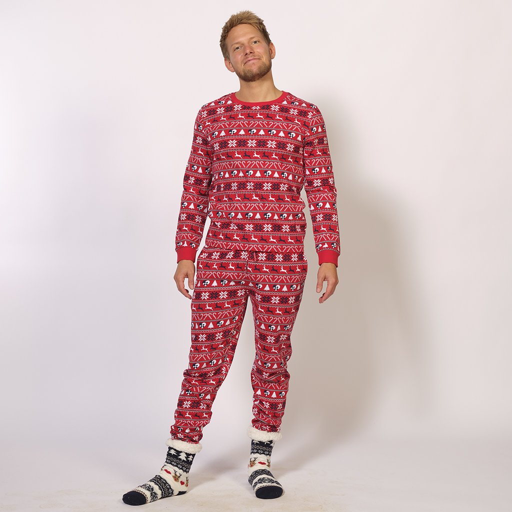 Un uomo che indossa un pigiama rosso con motivi natalizi.